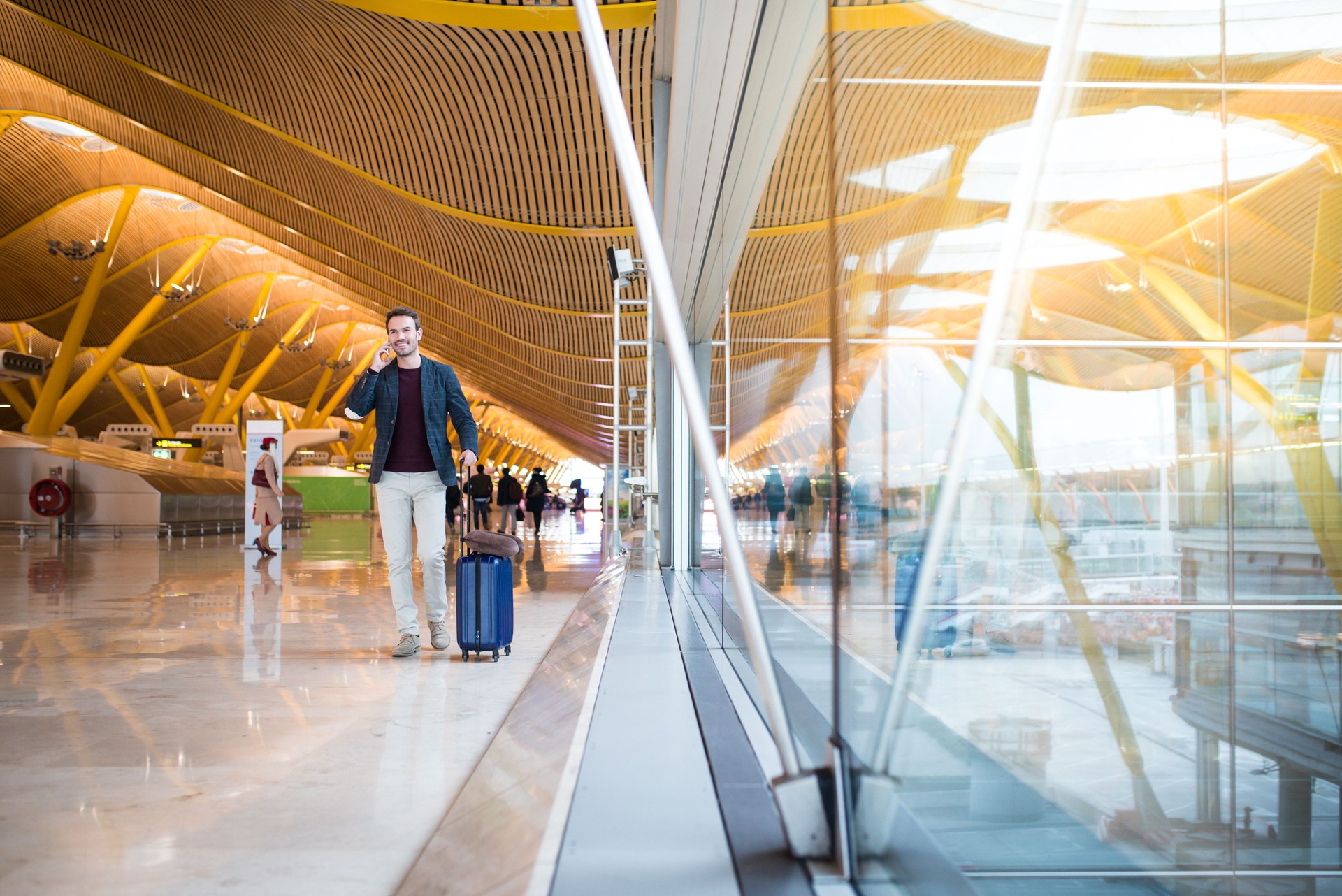 man front walking at the airport using mobile phone